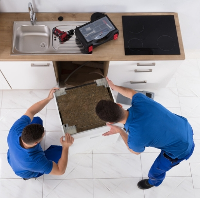 two men doing Kitchen plumbing repair on a dishwasher